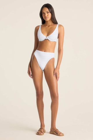 Woman wearing a white bikini top with underwire and matching swim bottoms