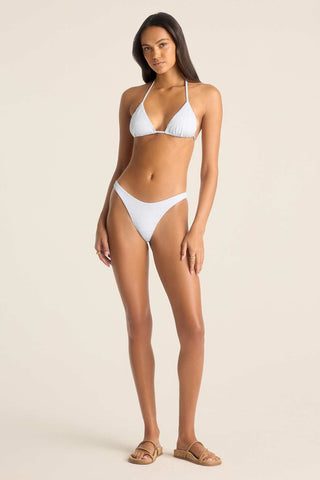 Woman wearing a white string bikini top with matching swim bottoms