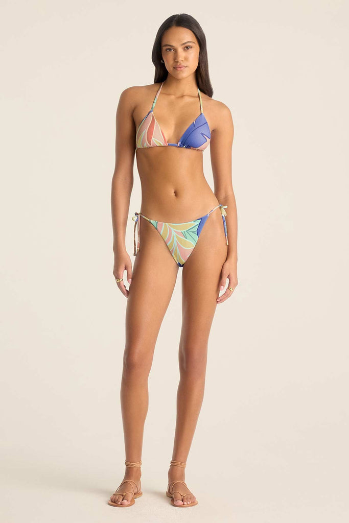 Woman wearing a jungle printed bikini top and matching swim bottoms 