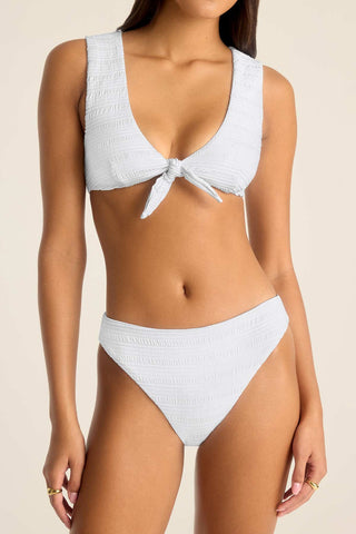 Woman wearing a white swim top with matching white swim bottoms