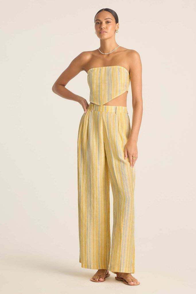 Woman wearing a yellow and blue striped scarf beach top and matching beach pants