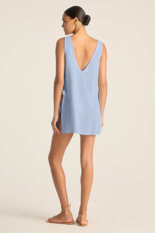 Woman turned away wearing a light blue mini beach dress