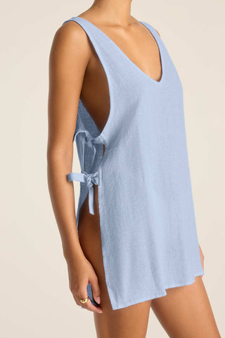 Woman turned right to show tie detail of light blue mini beach dress