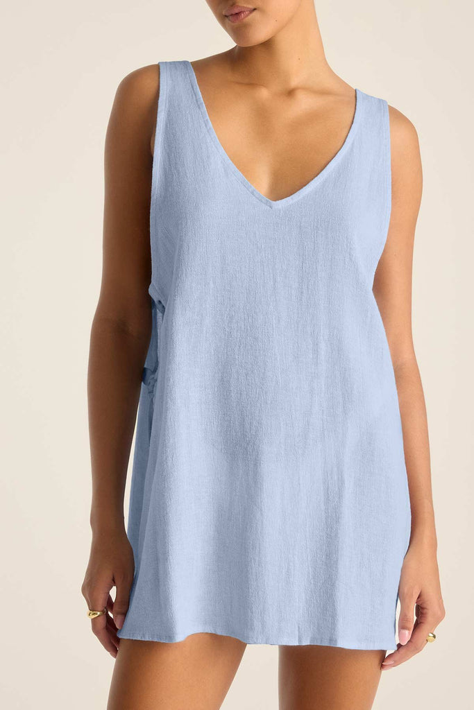 Woman wearing a light blue mini beach dress with close up