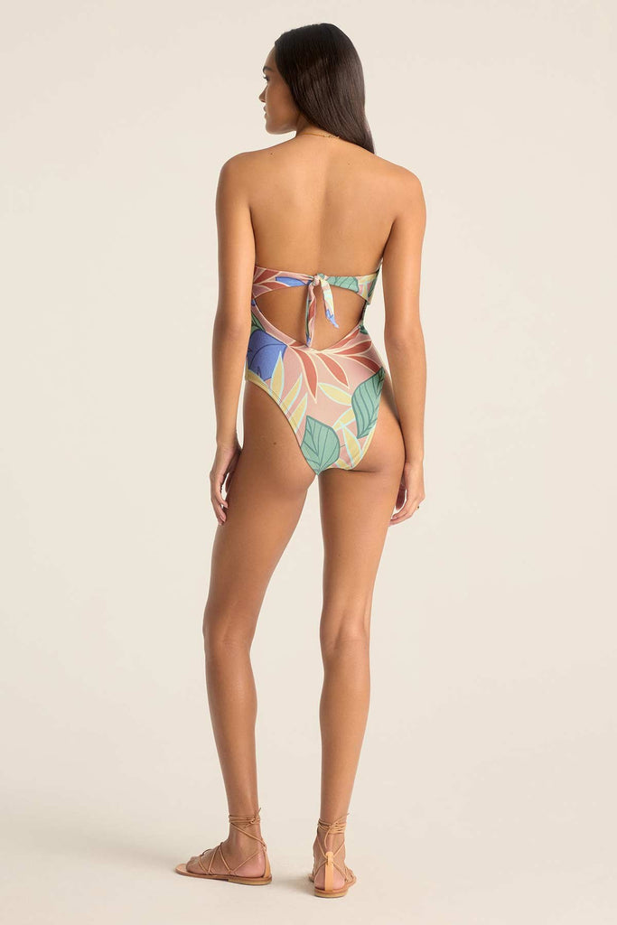 Woman turned away wearing a bandeau one-piece jungle printed swimsuit
